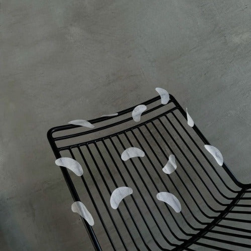 fond gris et chaise noire avec patchs gris collés dessus